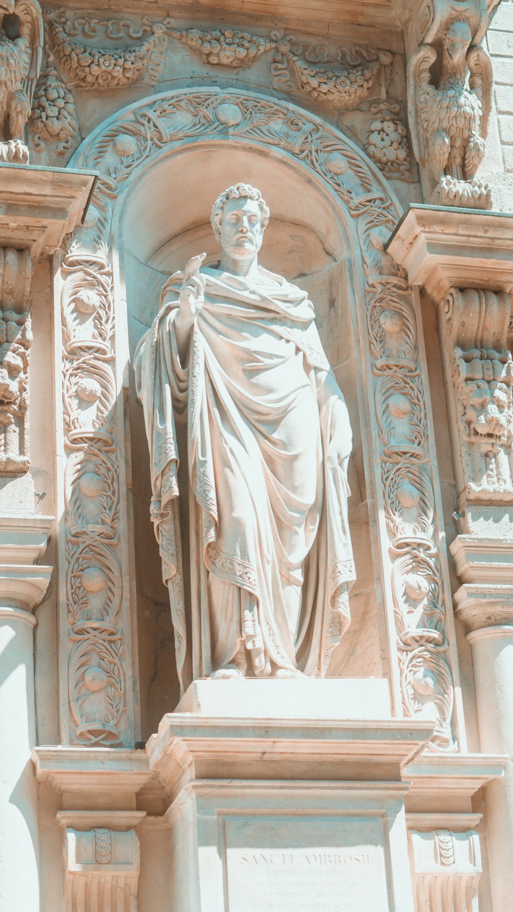 a statue of a man with a cloak on top of a building