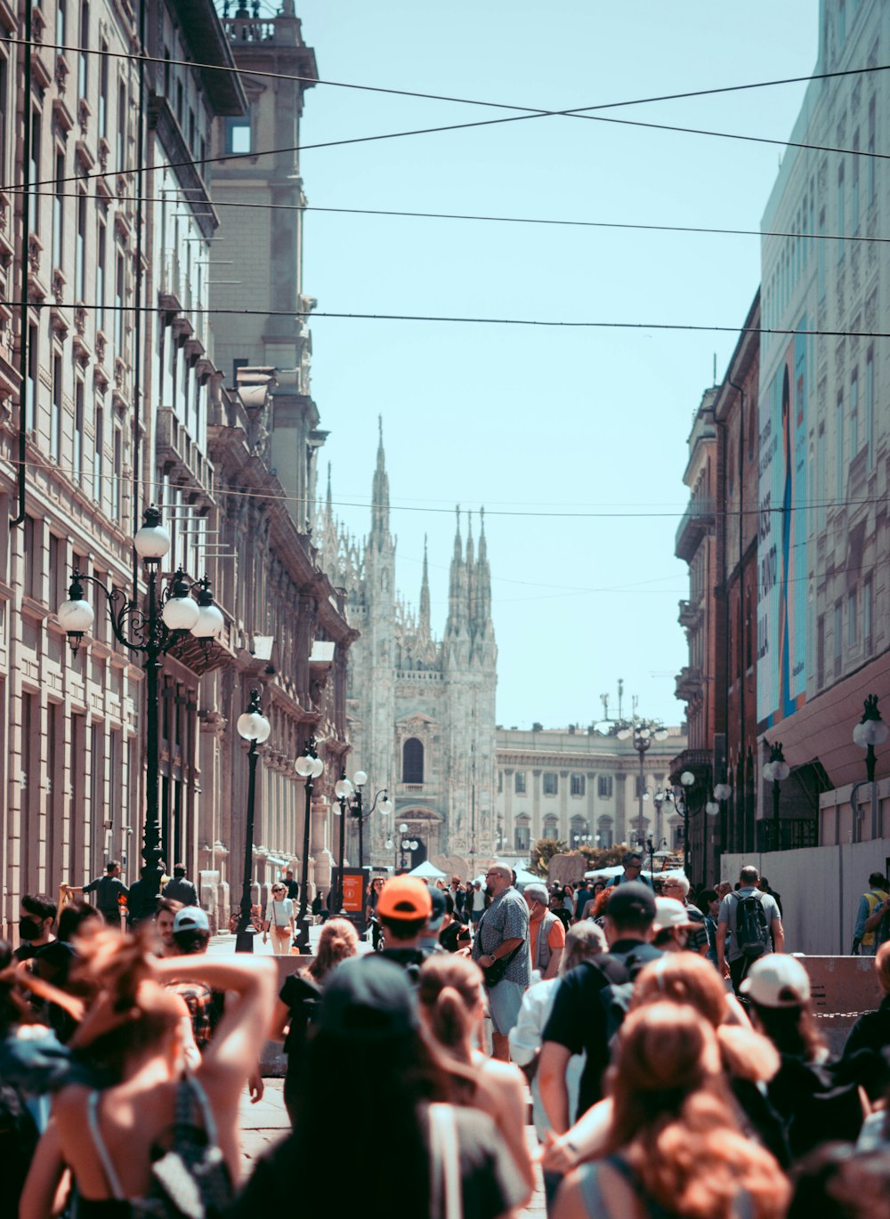 a crowd of people walking down a street next to tall buildings