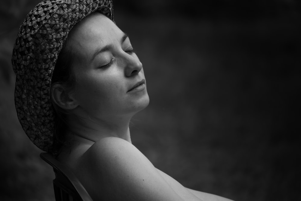 a woman with her eyes closed wearing a hat