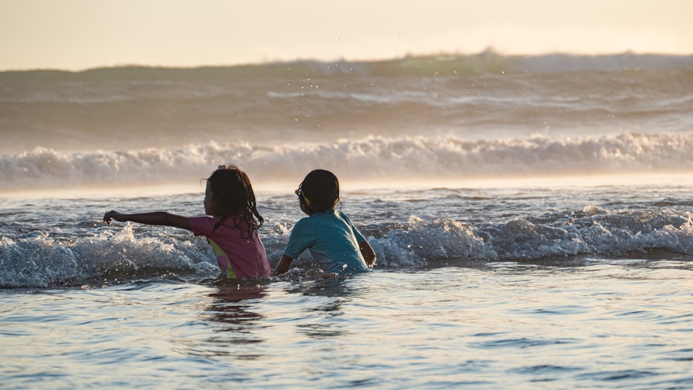 two children playing in the water at the beach