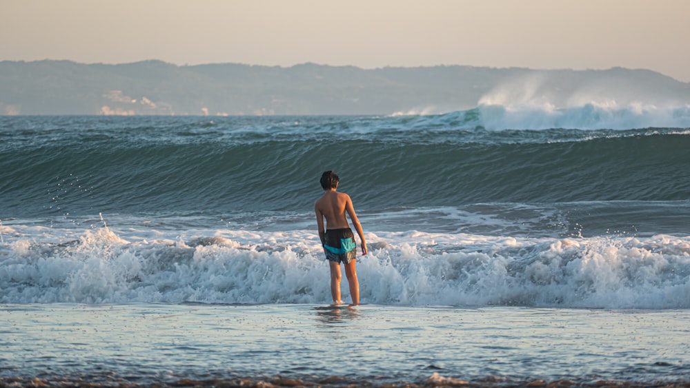 a man standing on a surfboard in the ocean