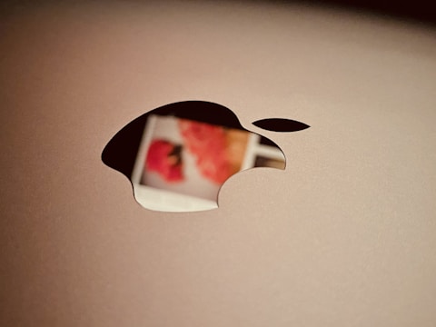 a close up of an apple logo on a laptop