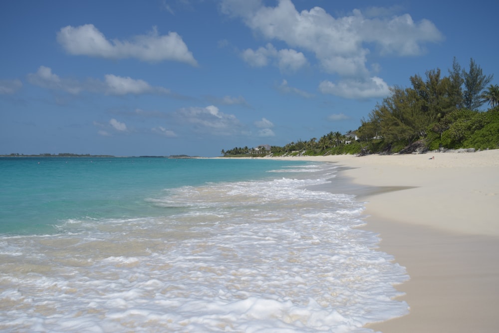 a sandy beach with clear blue water and white sand