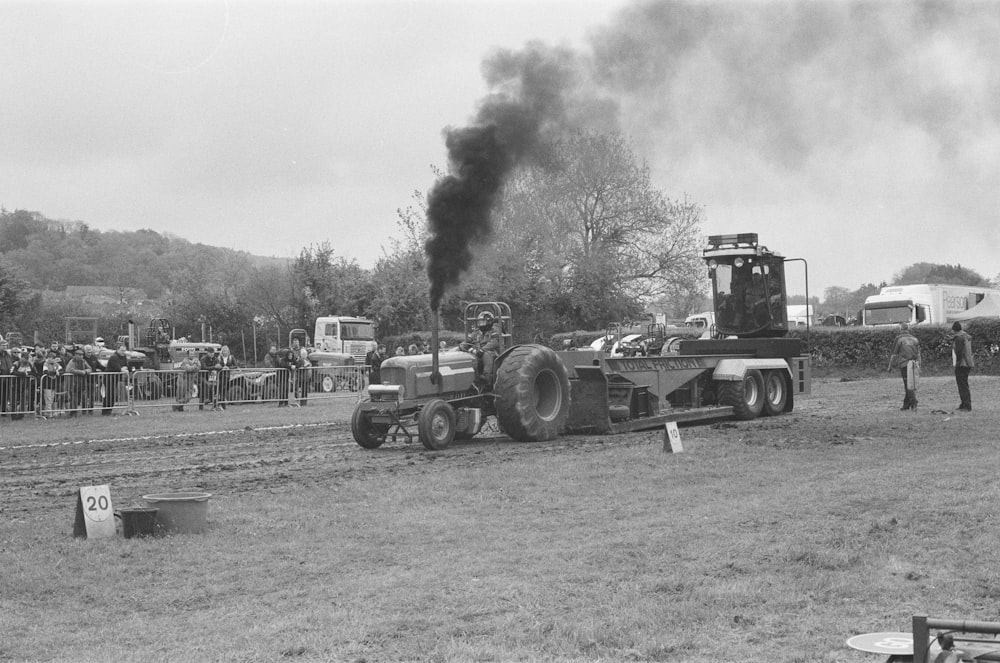 a black and white photo of a tractor pulling a trailer