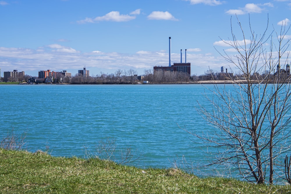 a large body of water with a factory in the background