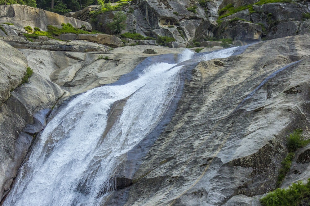 a large waterfall is coming down a rocky mountain