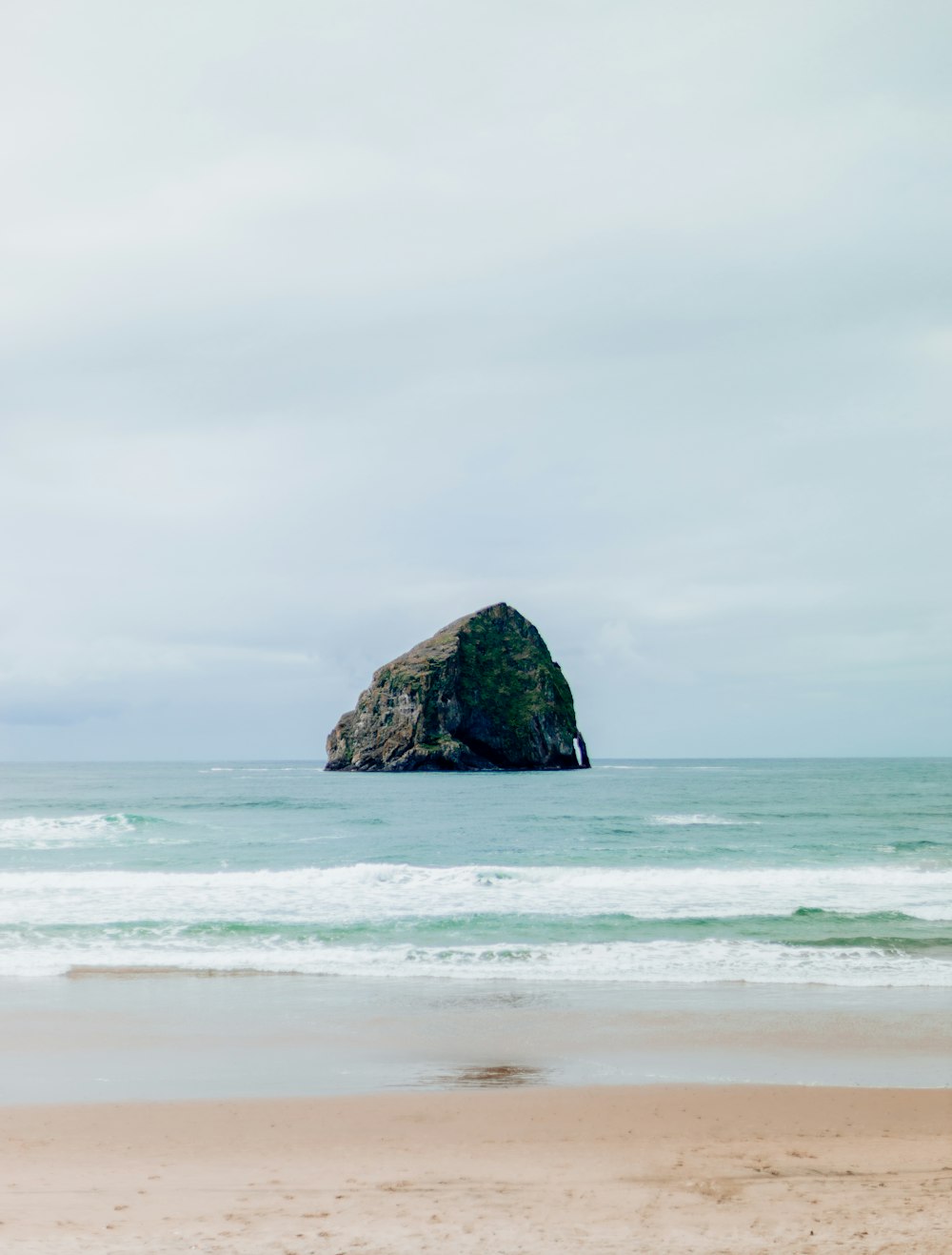 a large rock sticking out of the ocean