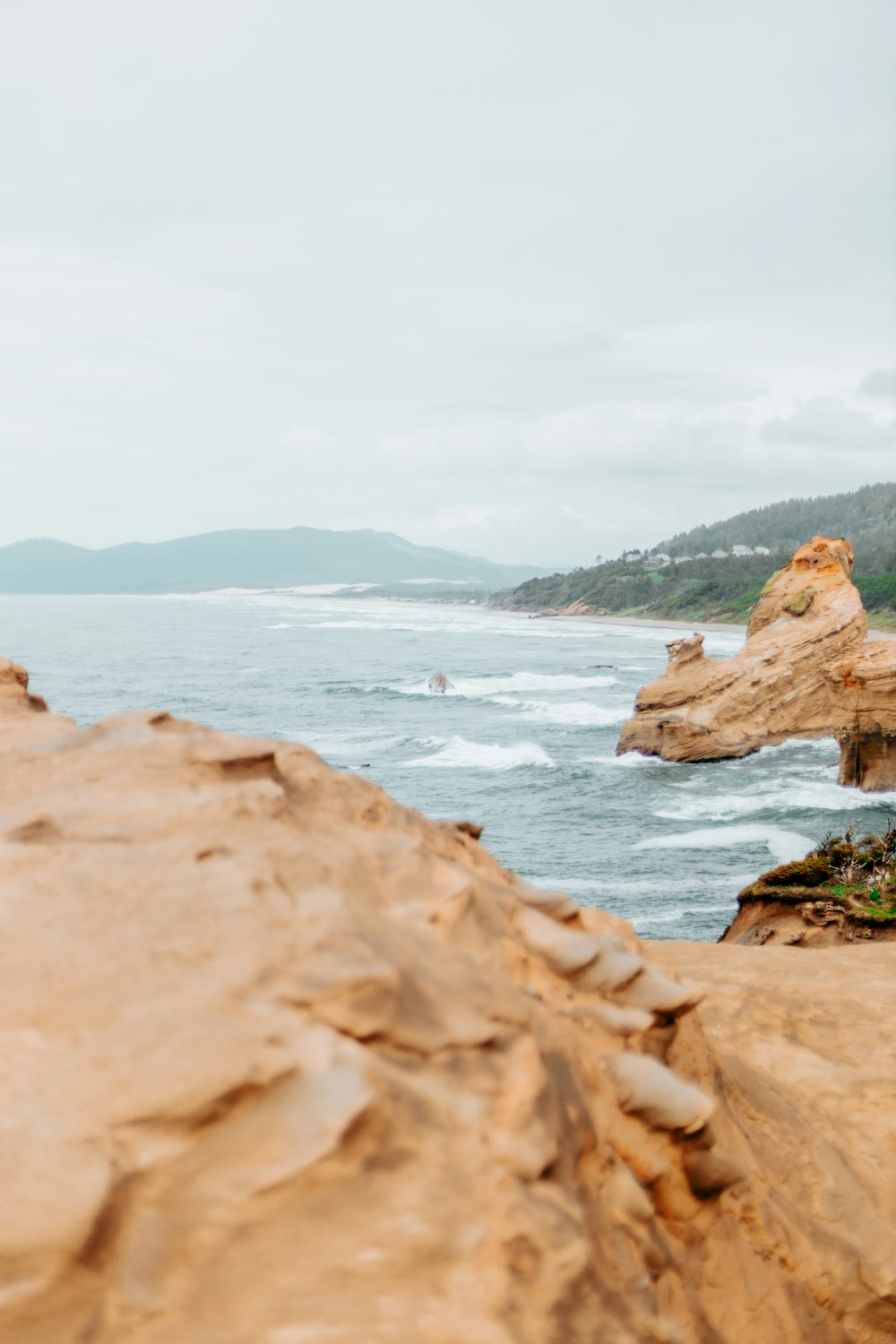 a person standing on top of a cliff next to the ocean