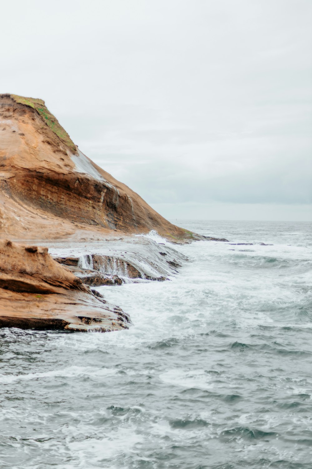 a large body of water sitting next to a rocky cliff