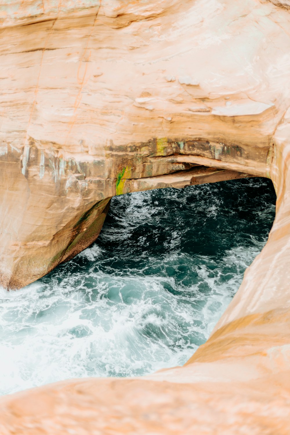 a man standing on the edge of a cliff next to a body of water