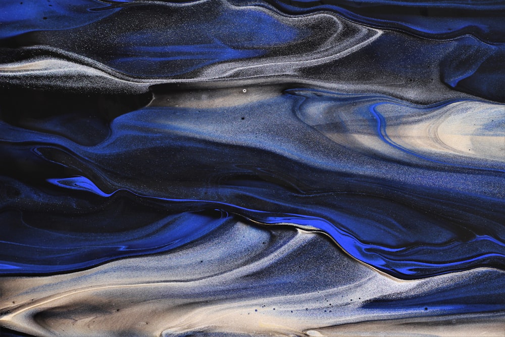 a blue and white abstract painting with a black background