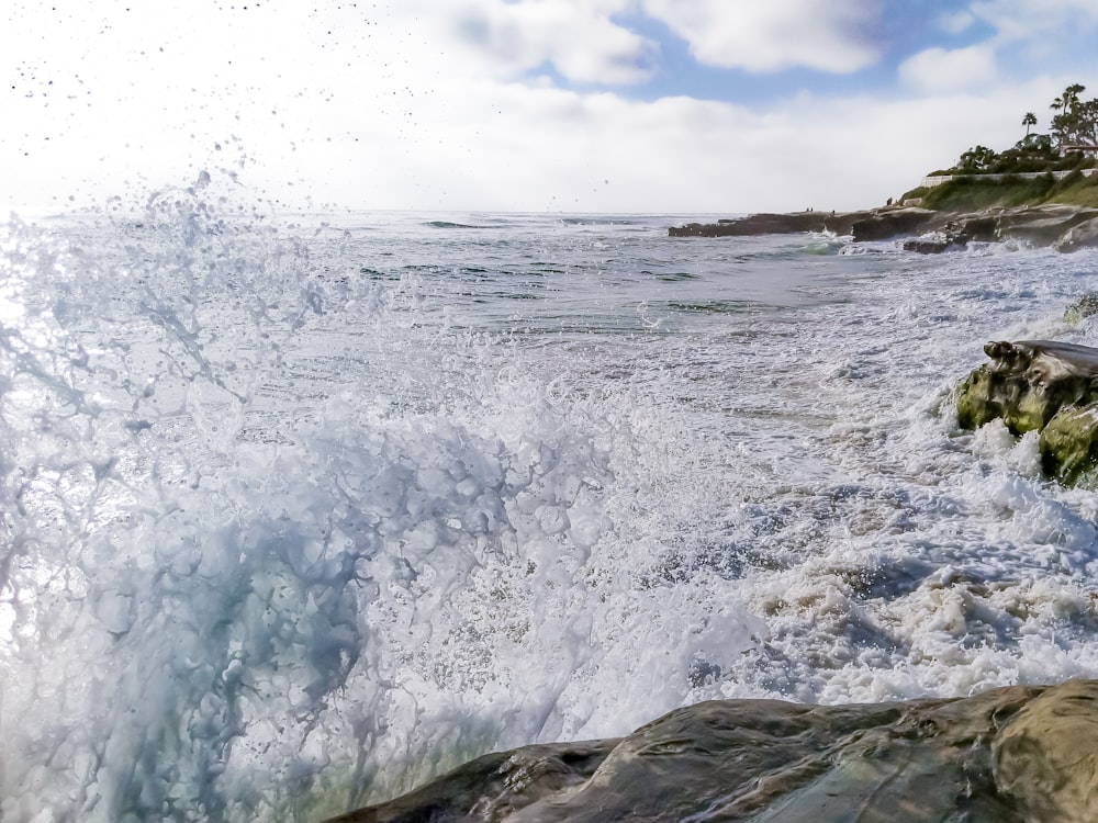 a large wave crashing into the shore of a beach