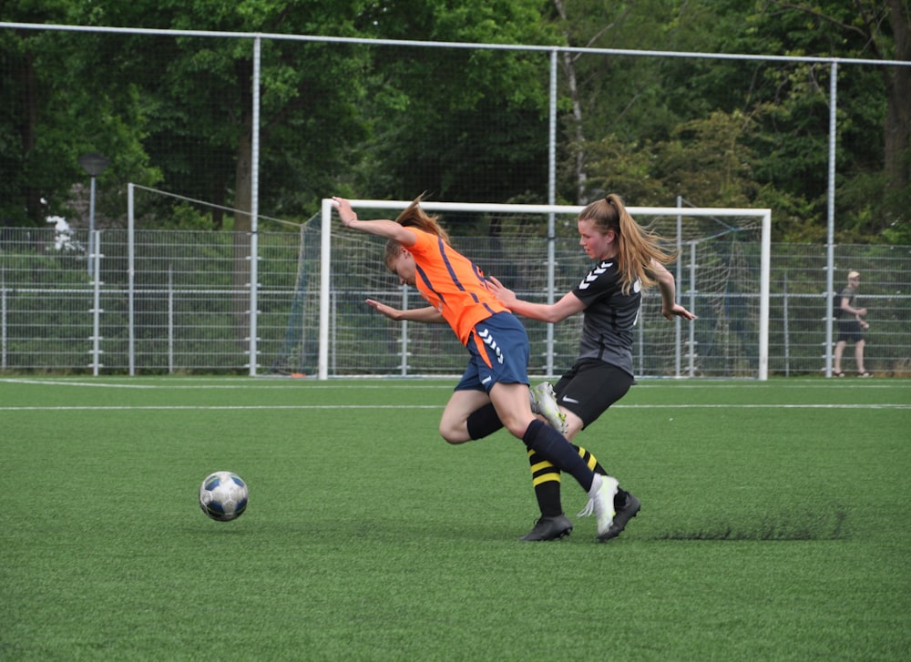 a couple of girls playing a game of soccer