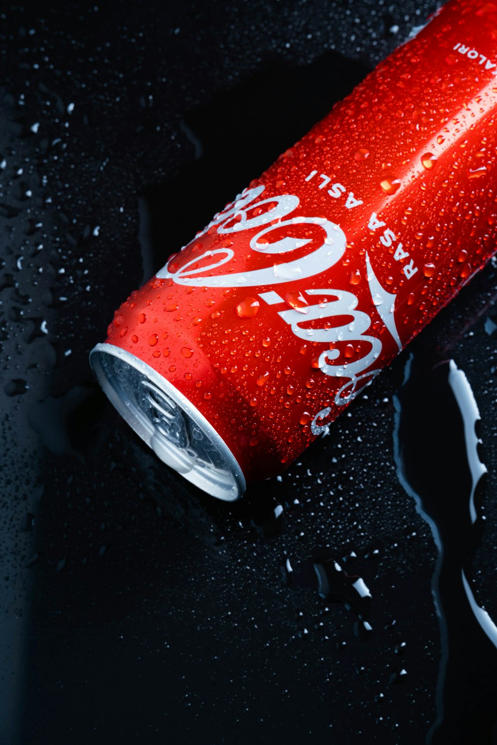 a can of coca - cola on a wet surface