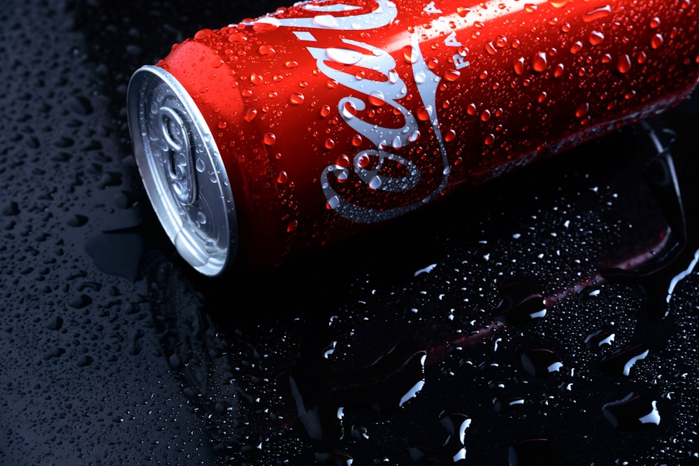 a can of coca - cola on a wet surface