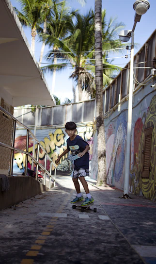 Young boy in colorful urban streetwear playing in a skate park with a confident smile.