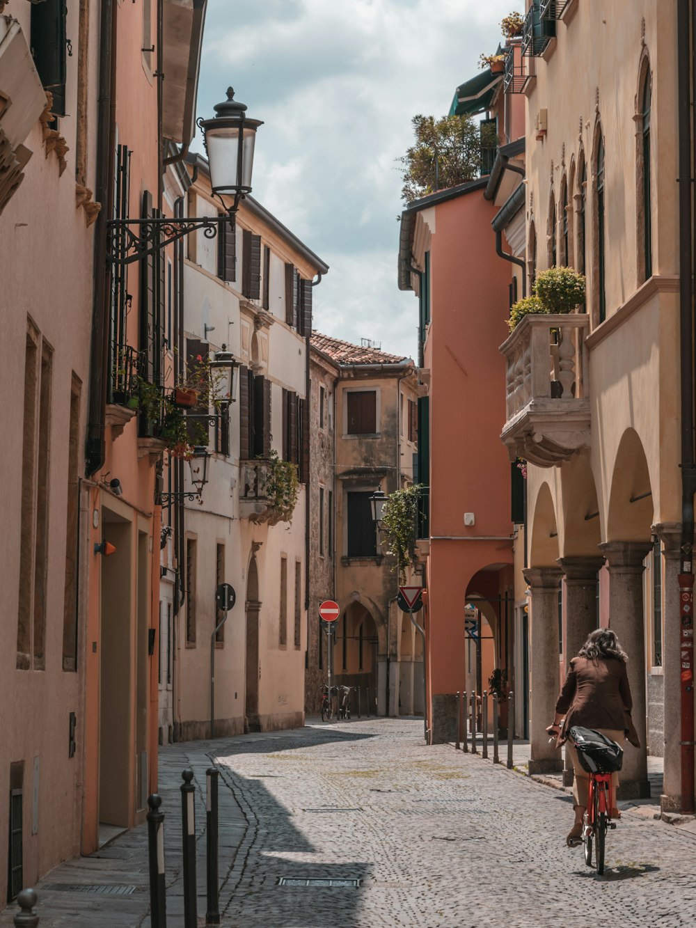 a man riding a bike down a cobblestone street