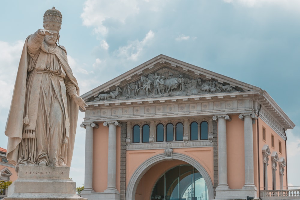 a statue of a man standing in front of a building