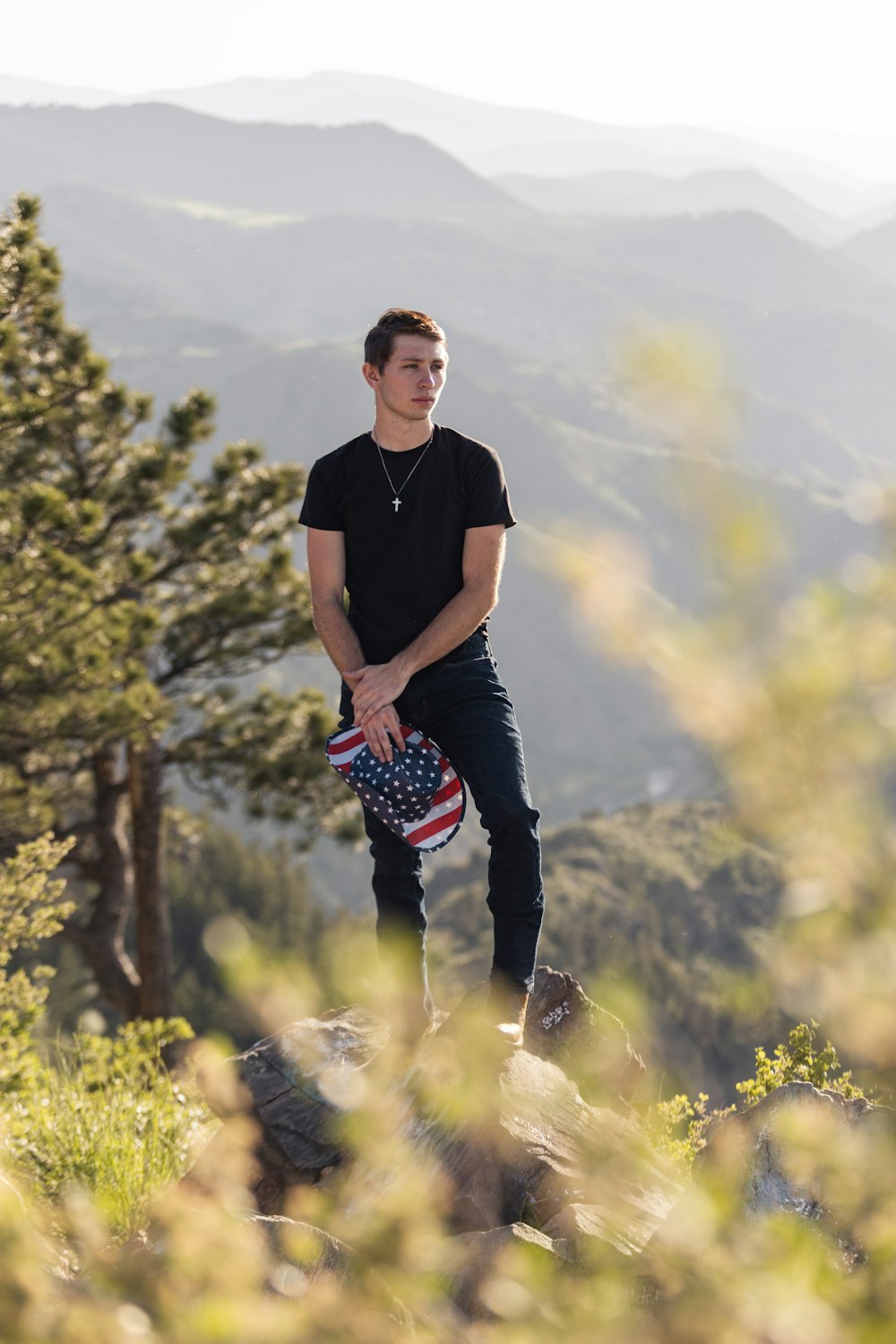 a young man standing on top of a mountain