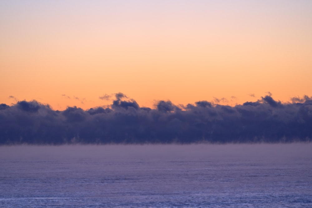 a large body of water with clouds in the sky