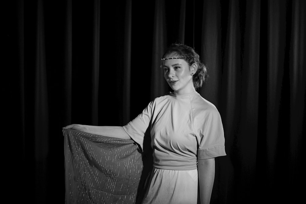 a black and white photo of a woman holding a piece of cloth