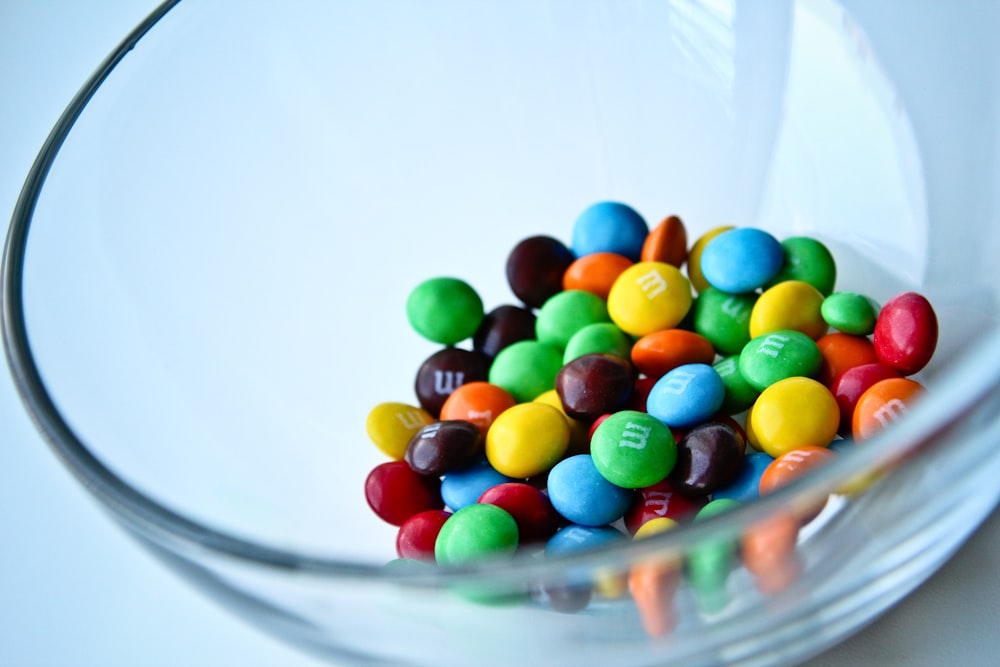 a glass bowl filled with lots of colorful candy