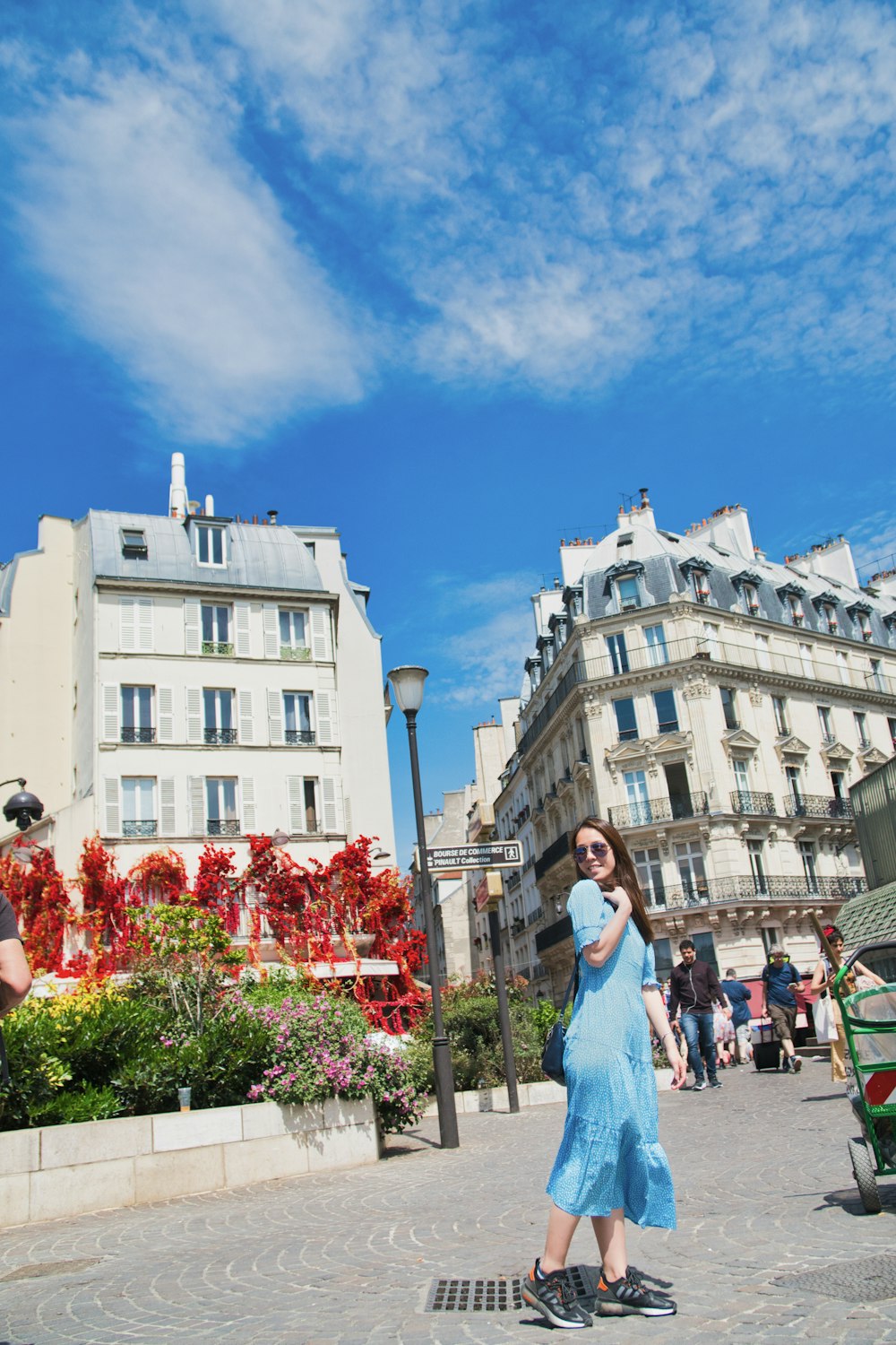 a woman in a blue dress standing in front of a building