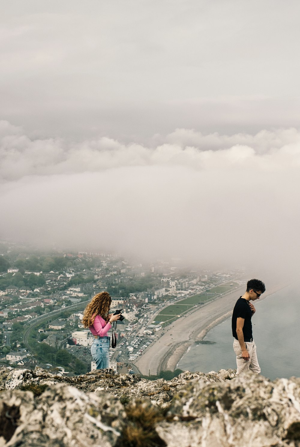 a man and a woman standing on top of a mountain