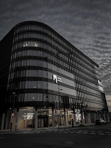 Commercial property with dark glass facade and golden trim in a busy business district.