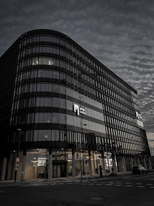 Commercial property with dark glass facade and golden trim in a busy business district.