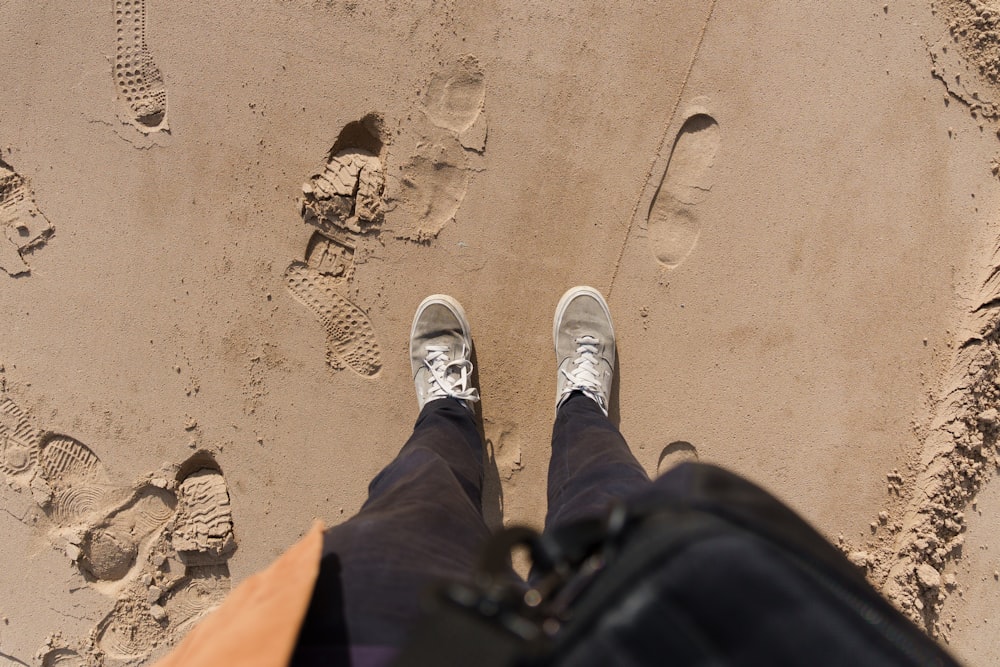 a person standing on top of a sandy beach