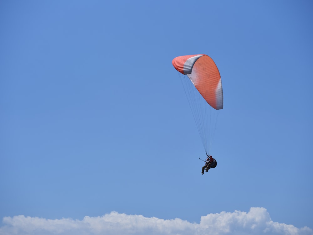 a person is parasailing in the blue sky