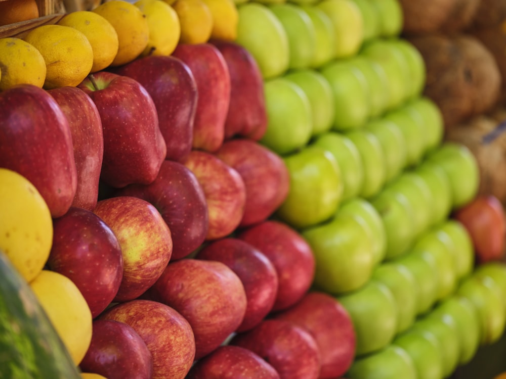 uma exposição de maçãs e outras frutas em uma loja