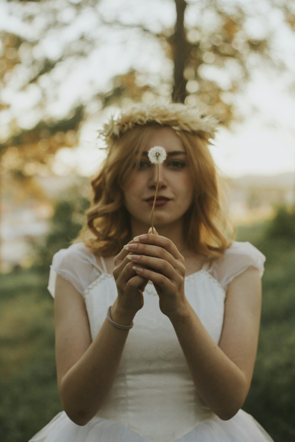 a woman in a white dress holding a flower