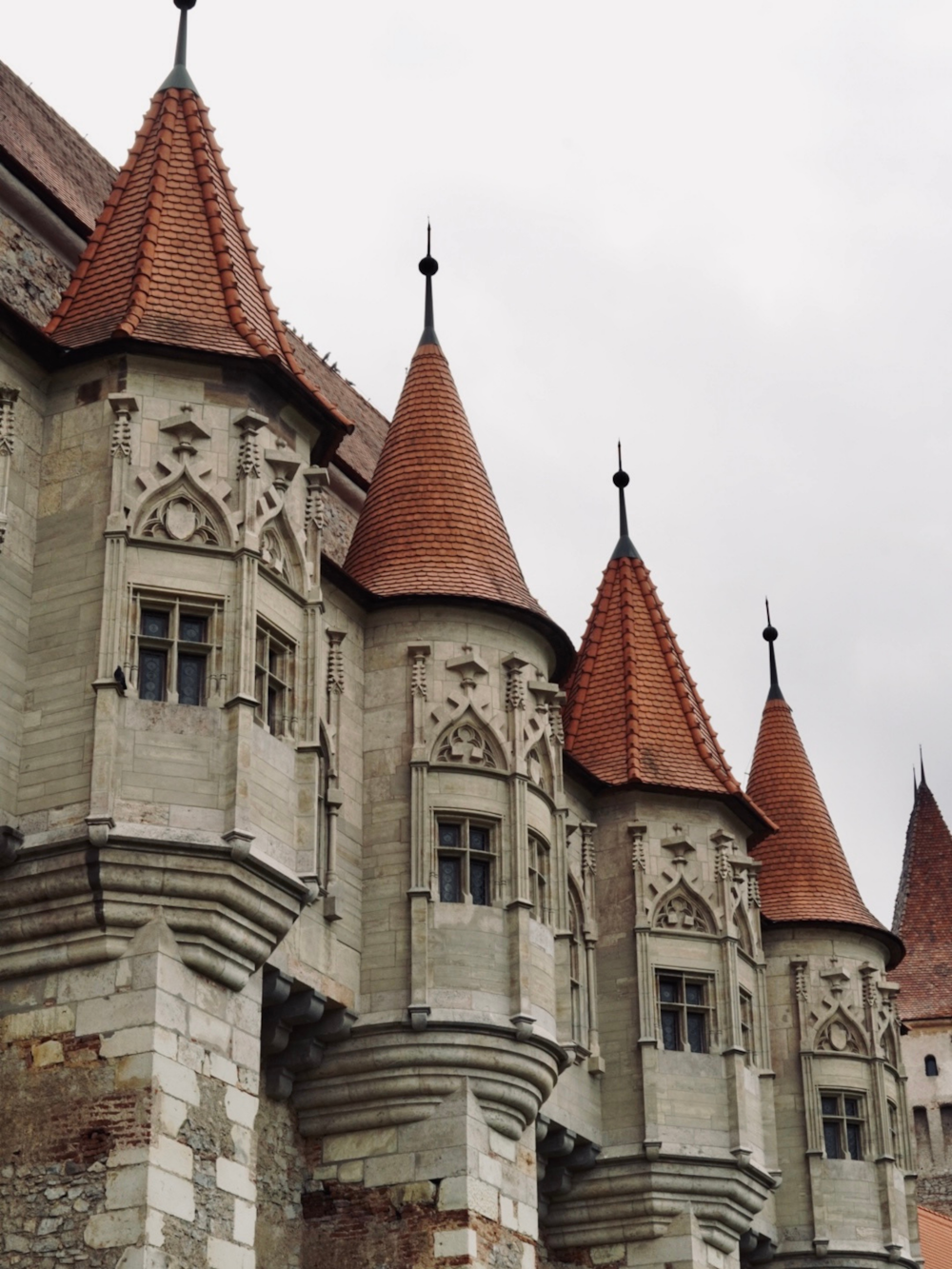 a row of old castle like buildings on a cloudy day