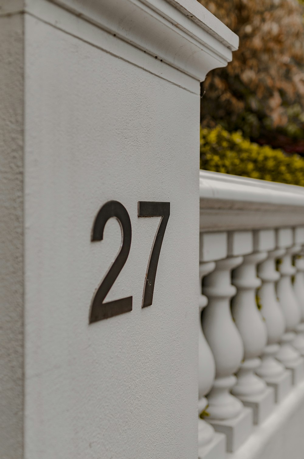 a close up of a number on a white fence