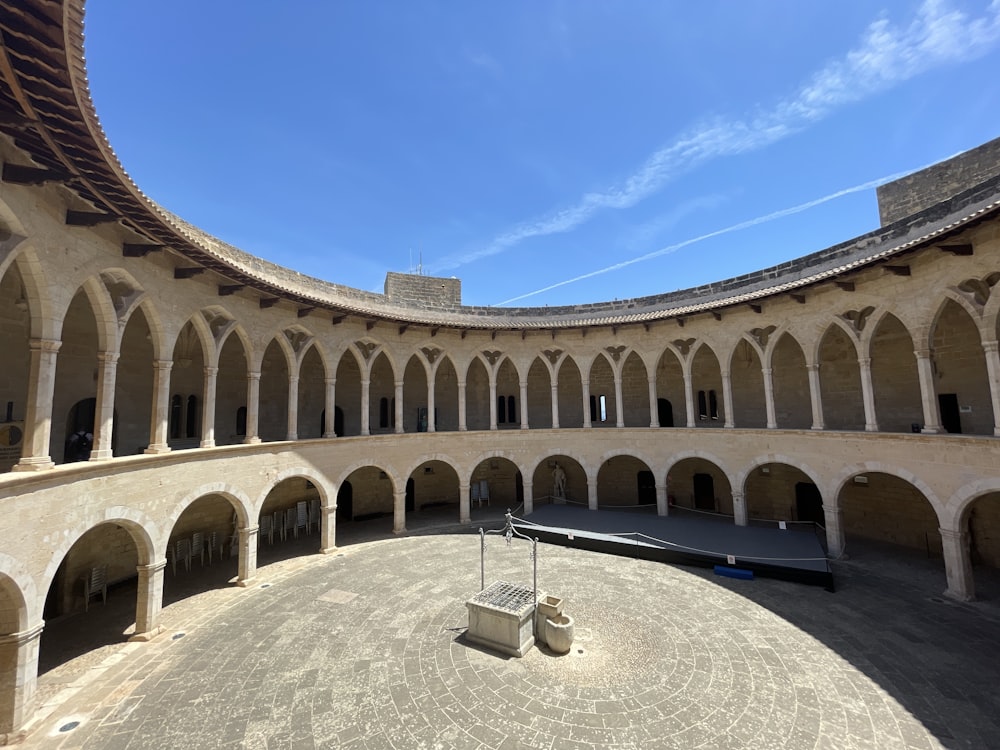 a circular building with arches and a bench in the middle