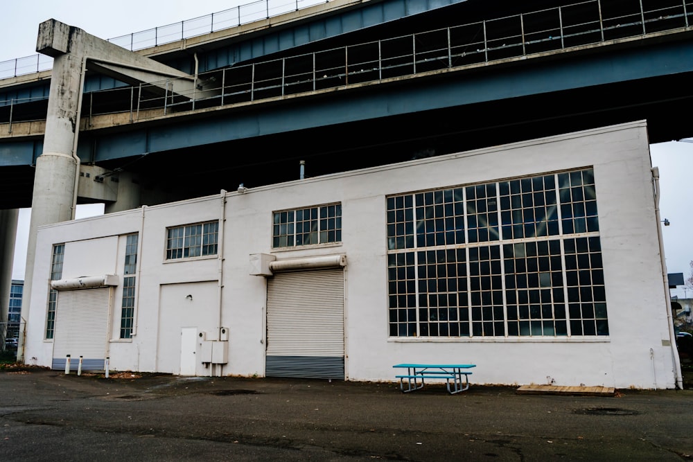 a white building with a blue bench in front of it