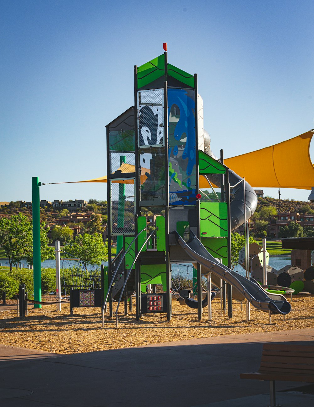a children's play structure with a slide in the background