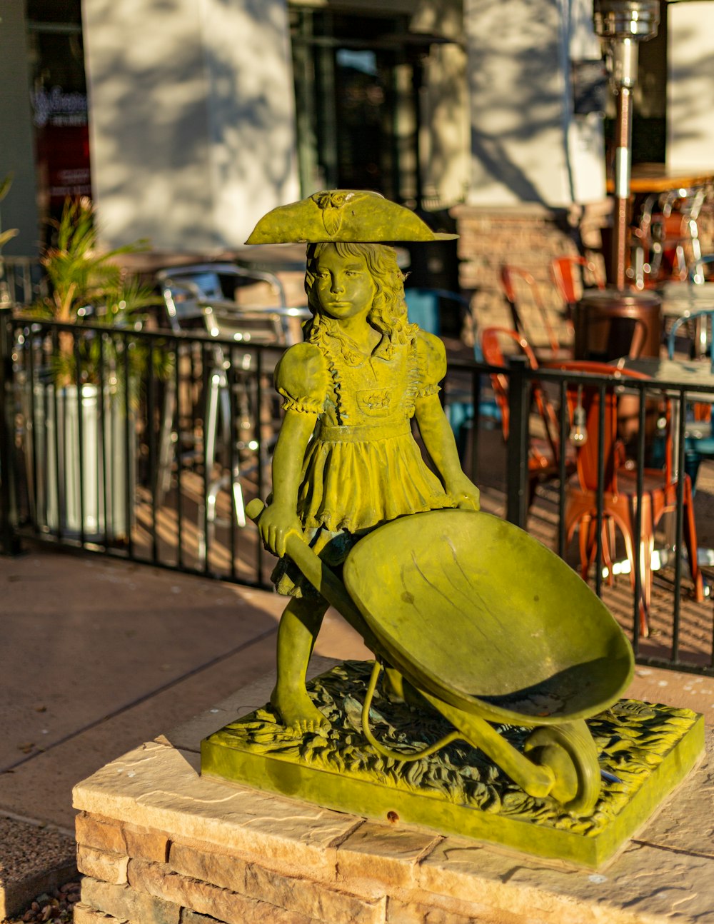 a statue of a woman holding a wheelbarrow