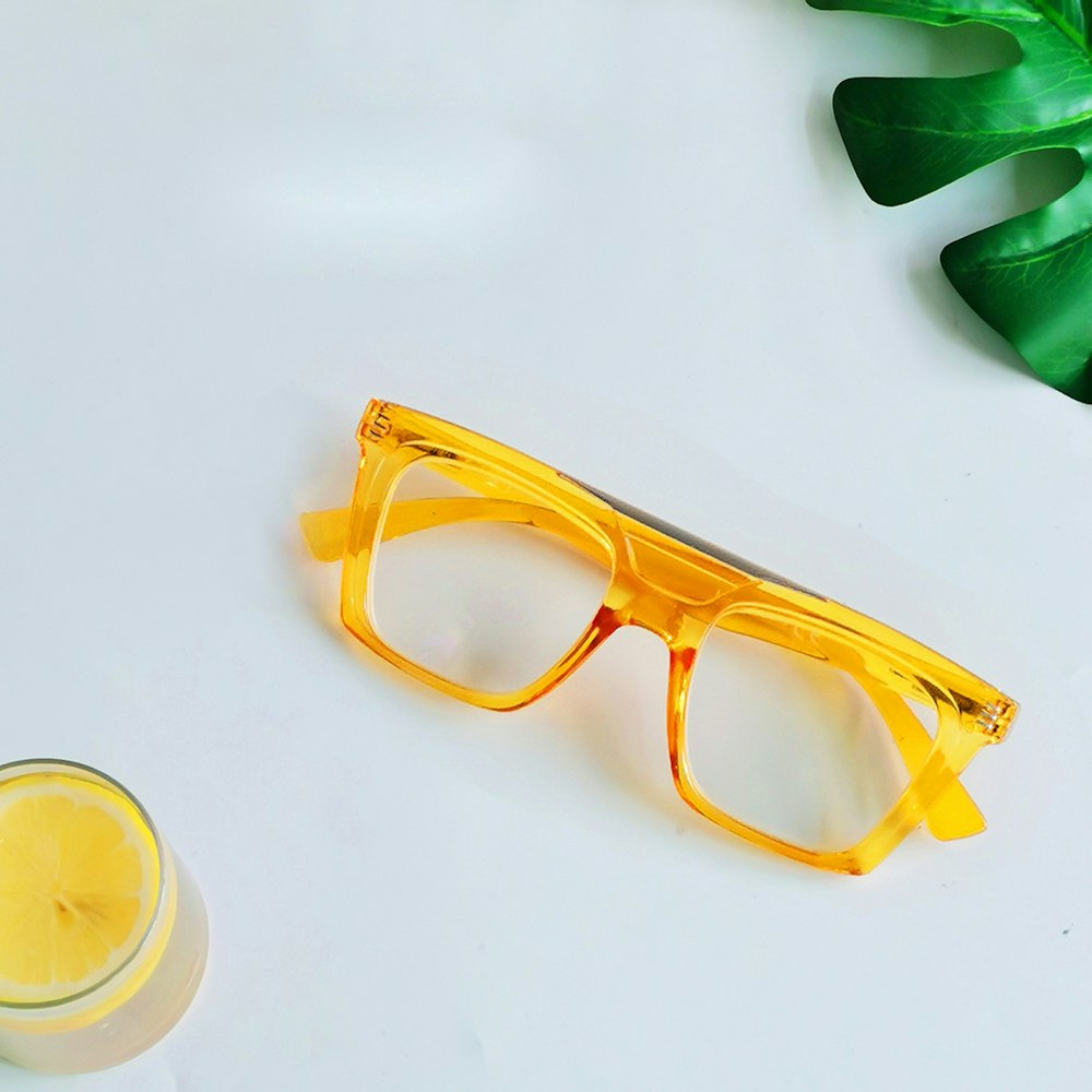 a pair of yellow glasses next to a glass of orange juice