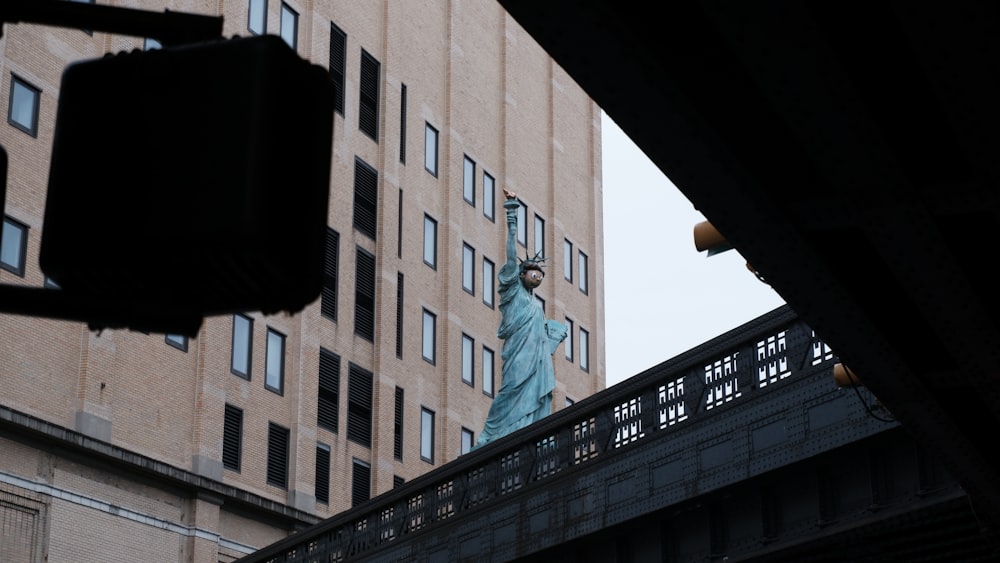 uma estátua da liberdade no topo de uma ponte