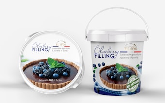 A pair of containers with blueberry filling. The front lid displays an image of a tart topped with blueberries and blackberries, garnished with mint leaves. The brand name 'Fil d'OR' is visible, promoting sustainable agriculture and quality. The larger bucket offers a similar design with additional text highlighting 'all natural ingredients' and the net weight of 6kg (13.4 lbs).