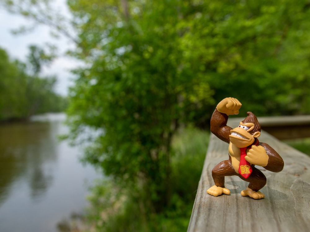 Une figurine de singe est posée sur une terrasse en bois