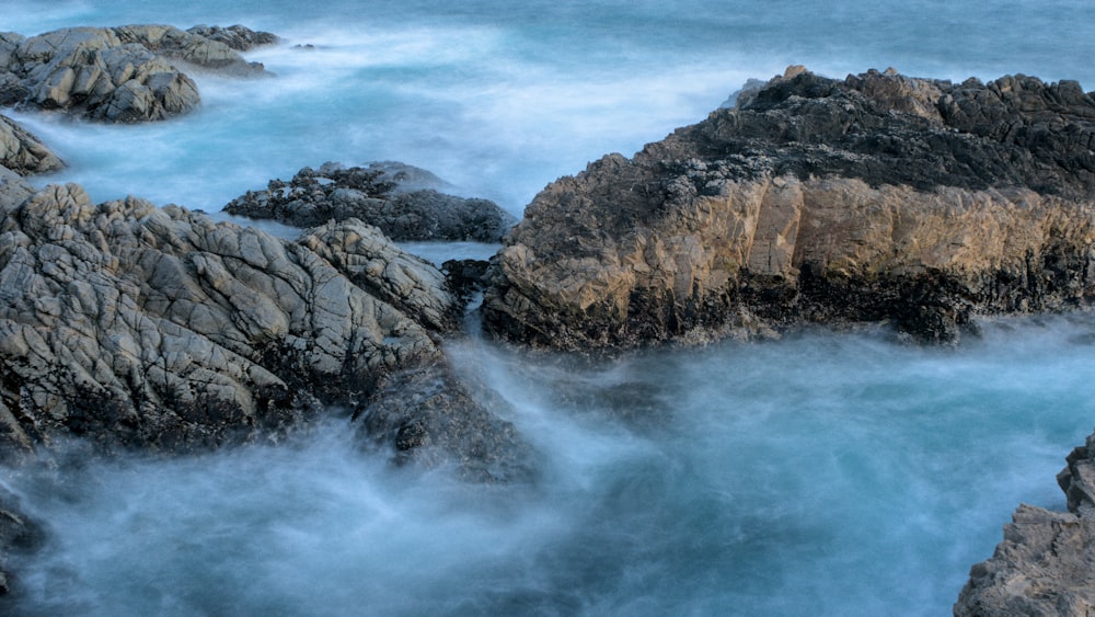 a rocky shore with blue water and rocks
