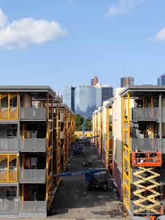 Modern apartment complex under construction with cranes and workers
