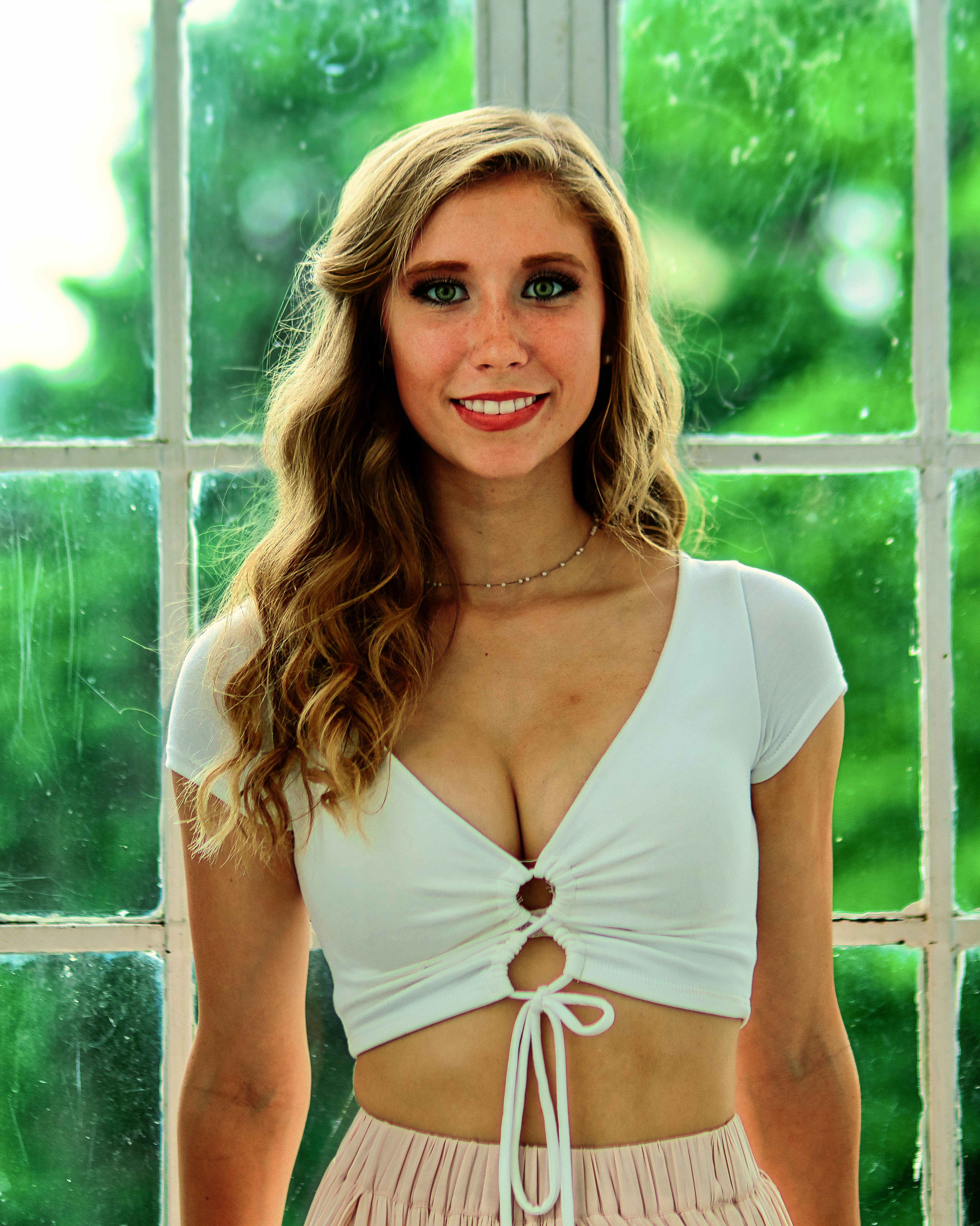 Una hermosa joven parada frente a una ventana