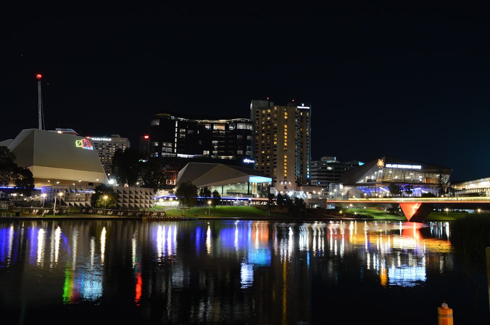 a city at night with lights reflecting in the water