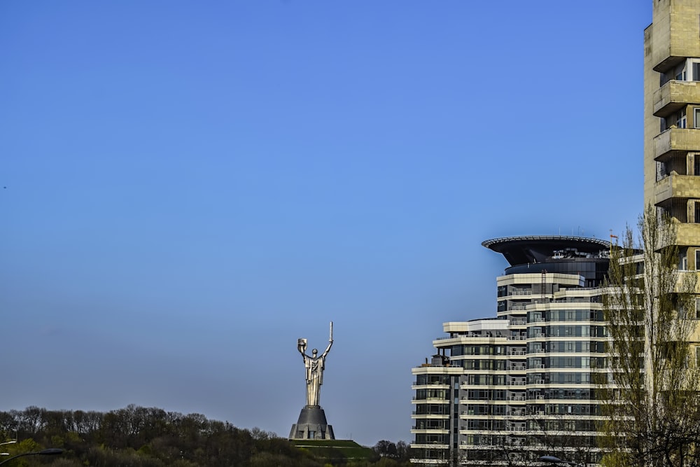 a tall building with a statue in front of it