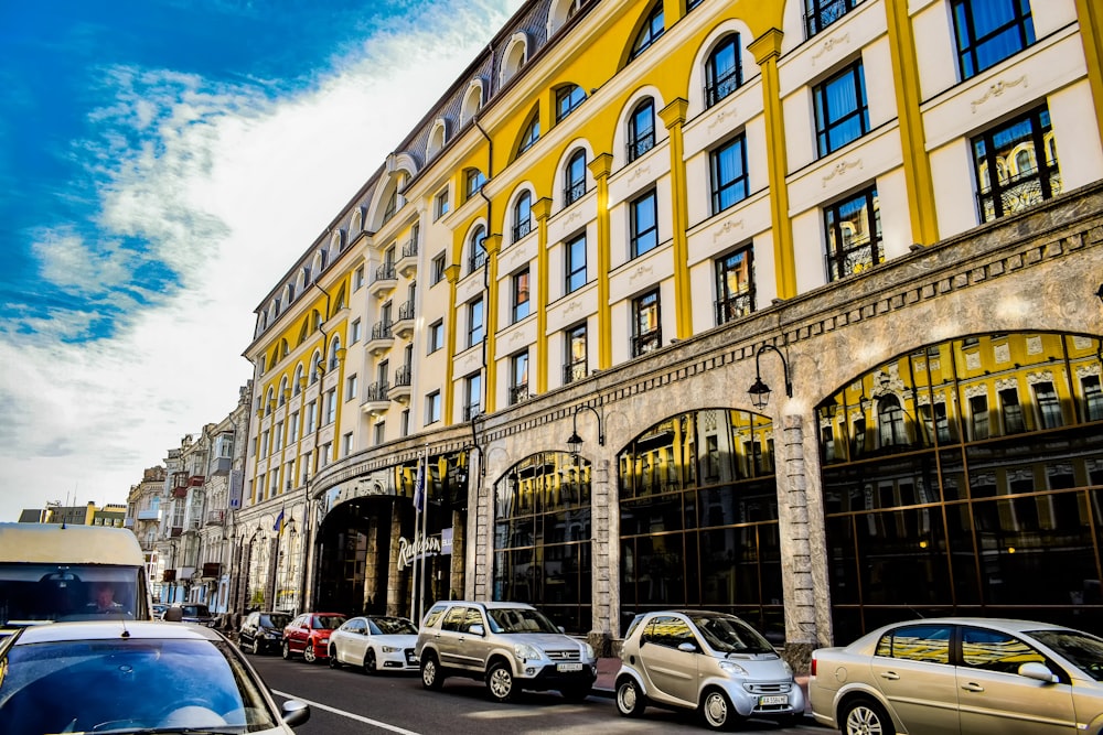 a group of cars parked in front of a tall building